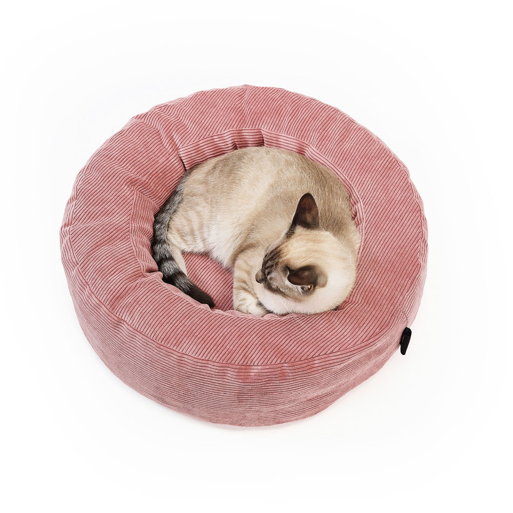 NEST kattenmand in roze, Siamese kat slaapt opgerold in de ronde corduroy mand