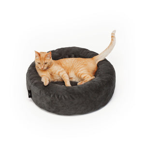 Rote Tigerkatze liegt im dunkelgrauen Cord-Katzenbett und schaut aufmerksam zur Seite